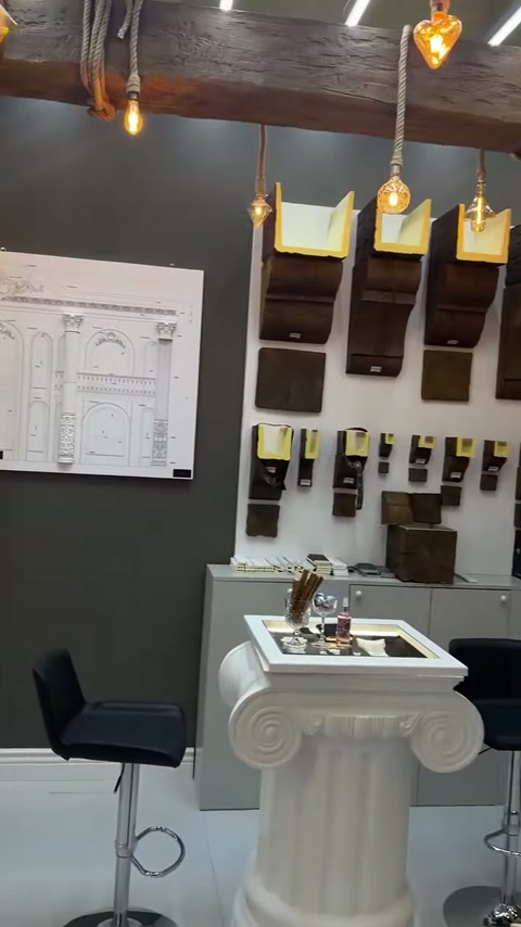 White capital-shaped table with dark-finished coating samples arranged in front