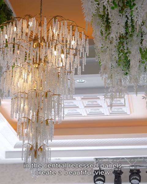 Pannelli soffitto in rilievo e illuminazione nascosta dietro lampadario in cristallo