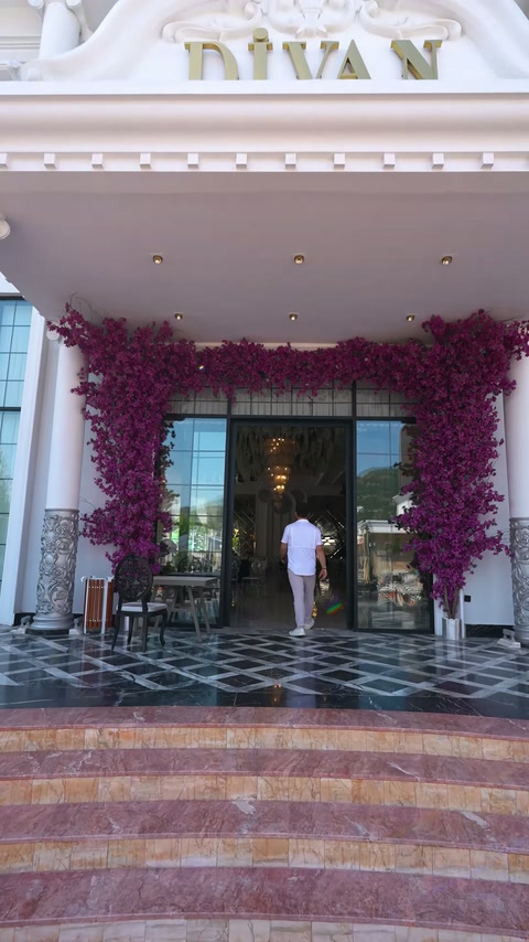 Çiçek kemeriyle süslenen camlı salon girişi dışarıdan görüntüleniyor