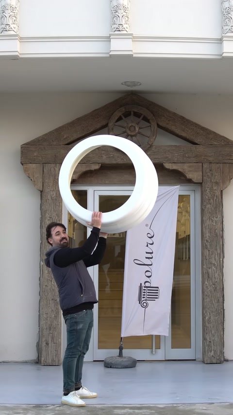 A white base ring is being lowered onto the round pedestal.