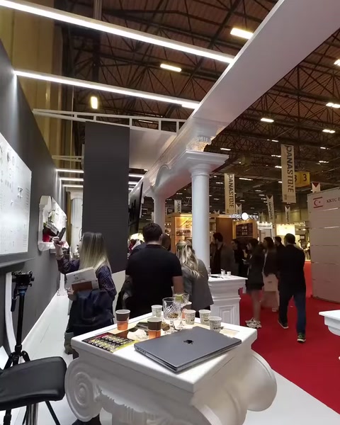 Allestimento espositivo con colonne disposte sotto una lunga trave decorativa