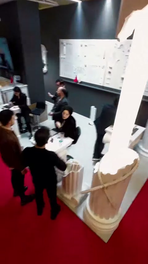 Yüksek açıdan sütun kaideleri, çalışma masası ve ziyaretçiler görülüyor