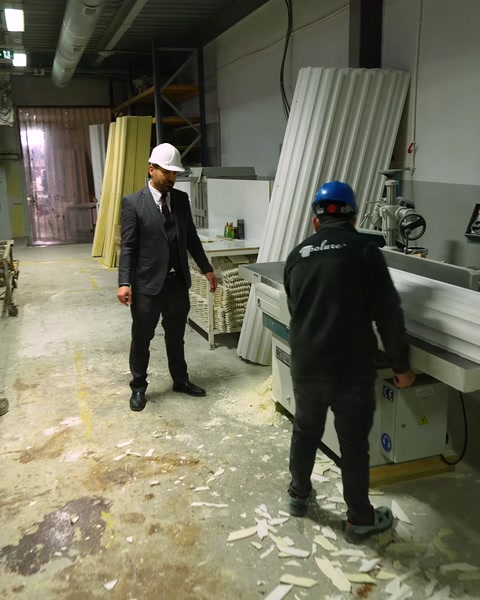 Worker walks toward polyurethane cutting machine in workshop