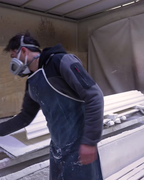 Worker wearing mask spray paints polyurethane column base