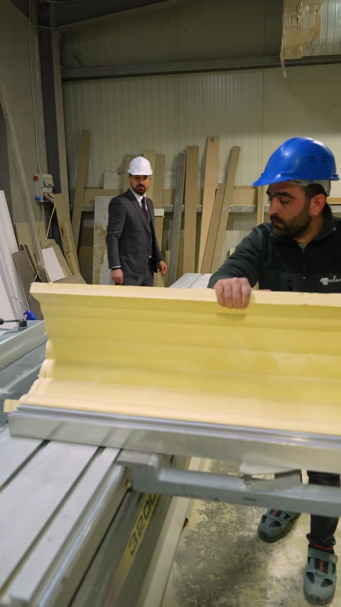 Craftsman inspects raw yellow polyurethane cornice profile closeup