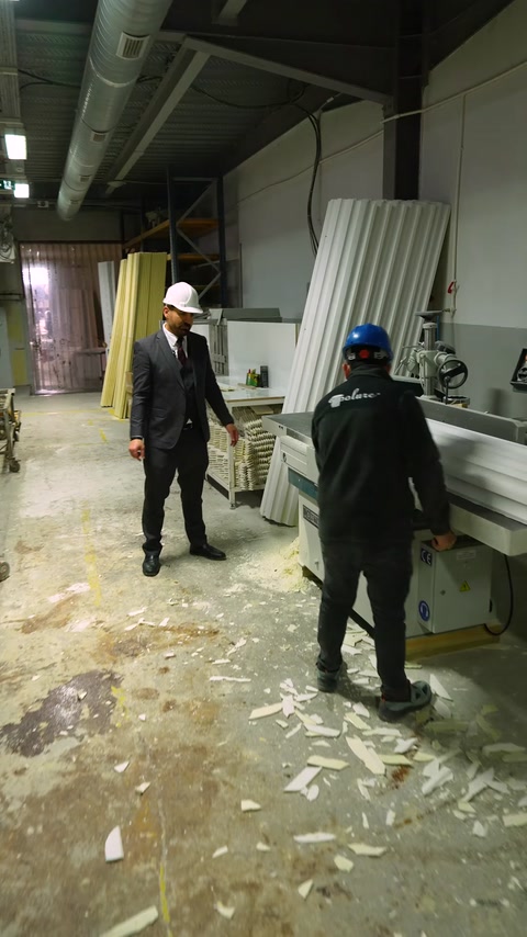 Worker walks toward polyurethane cutting machine in workshop