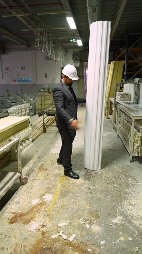Manager stands beside tall finished polyurethane decorative column