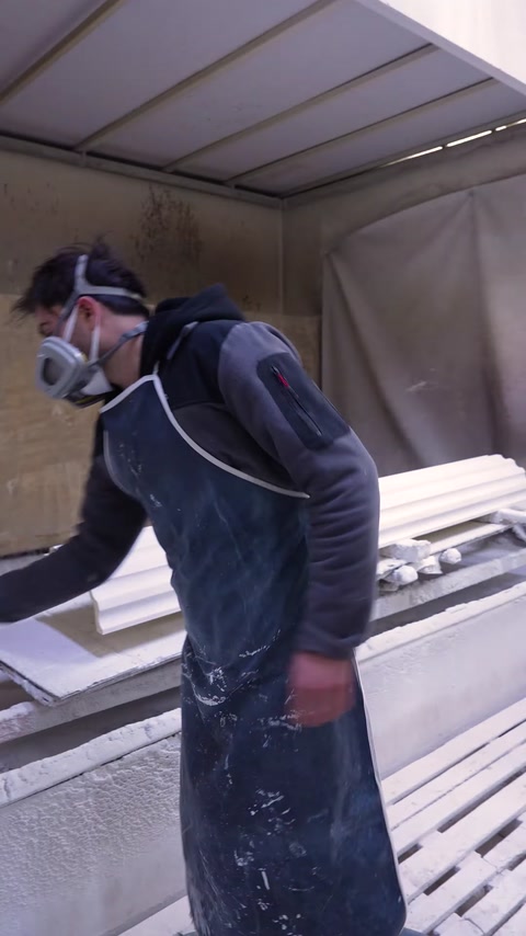 Worker wearing mask spray paints polyurethane column base