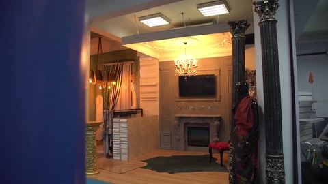 Ingresso dell'ambiente commerciale con colonna decorativa, illuminazione a soffitto e area espositiva
