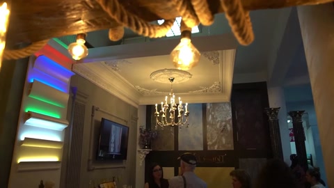 Vista d'insieme delle decorazioni a gradoni del soffitto, del lampadario e dei pannelli da parete