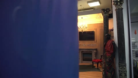 L'ingresso di un negozio di decorazione completato è parzialmente visibile dietro una partizione blu