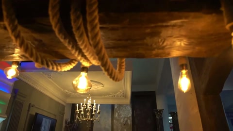 Gli elementi del soffitto con rivestimento a corda e lampadine dai colori caldi vengono esposti