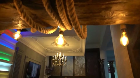 Le lampadine sospese tra le travi decorative del soffitto illuminano lo spazio