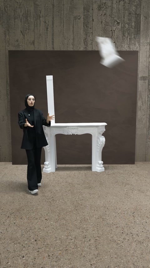 Şömine yanında duran çıtayla küçük süsleme parçası havada görülüyor