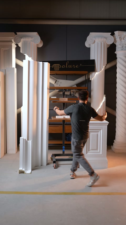 Usta, sergilenen pilaster ve sütun parçalarının önünden geçiyor.