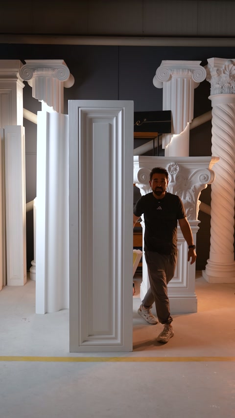 Usta, pilaster paneli ve bezemeli sütun kaidesi yanında duruyor.