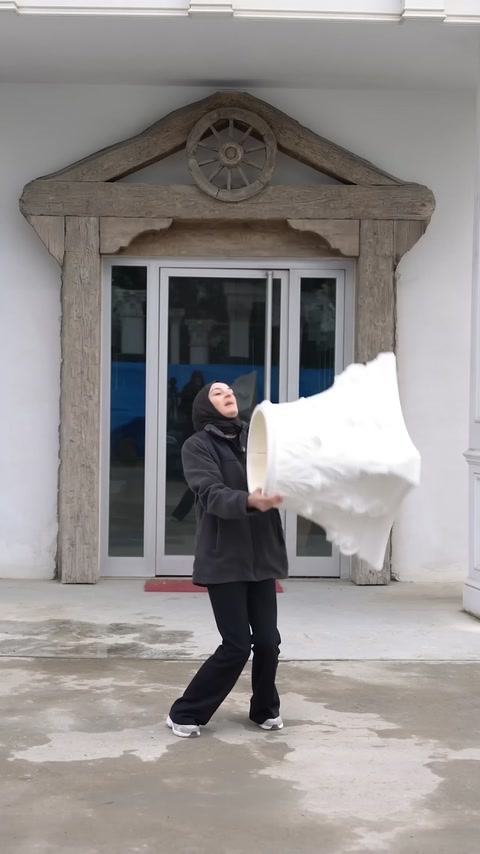 Il presentatore trasporta un grande capitello per colonna bianco in poliuretano all’esterno dello showroom.