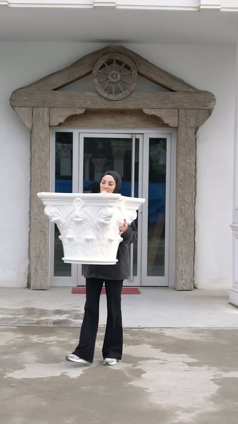 Il presentatore tiene il capitello frontalmente per mostrare la sua ornamentazione simmetrica.