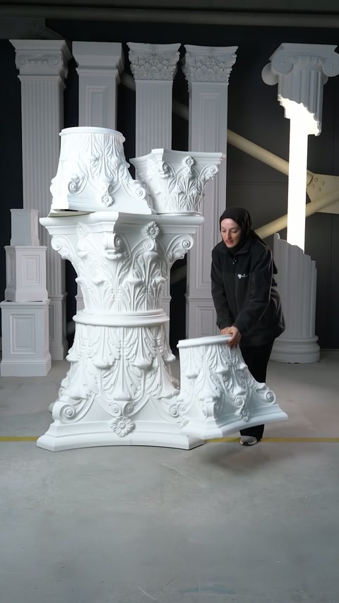 Il presentatore si piega per posizionare una sezione di capitello vicino al display sul pavimento.