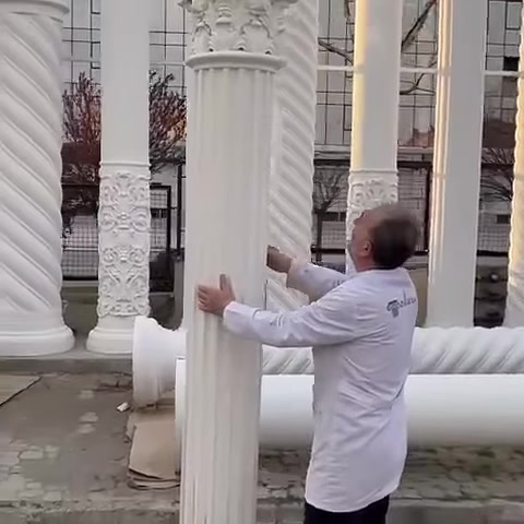 Un artigiano esamina il dettaglio del capitello nella parte superiore di una colonna scanalata