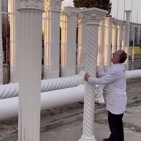 Una sottile colonna tortile è in posizione verticale con base e capitello