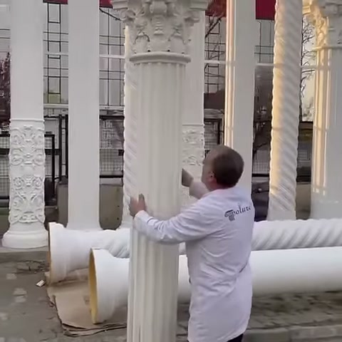 La colonna decorativa scanalata viene tenuta in posizione verticale durante il controllo dell'artigiano