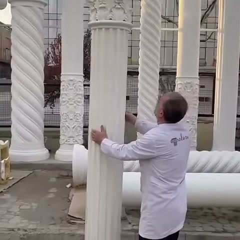 L'artigiano bilancia il pezzo di colonna scanalata tenendolo da entrambi i lati
