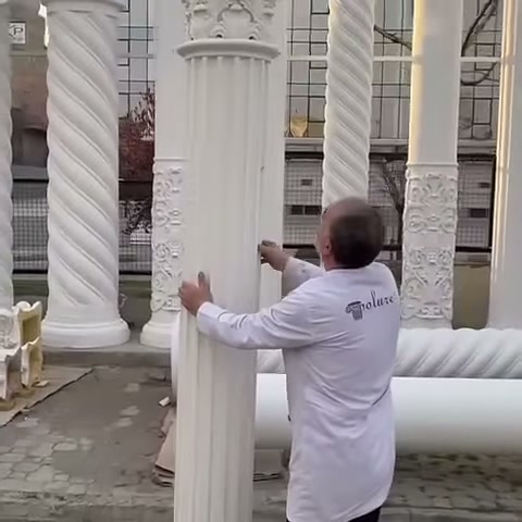 Il corpo della colonna bianca viene esaminato a mano nell'area espositiva all'aperto