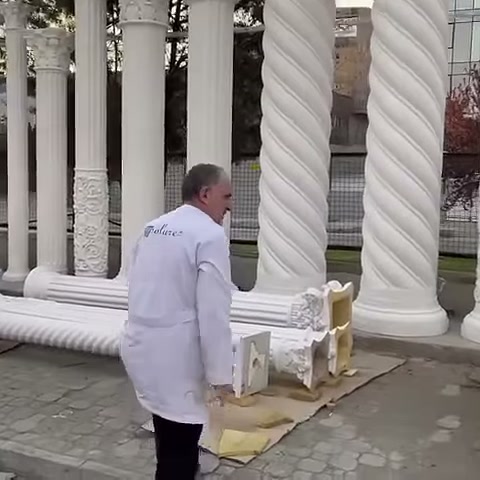 L'artigiano si avvicina alle colonne orizzontali accanto ai capitelli lavorati
