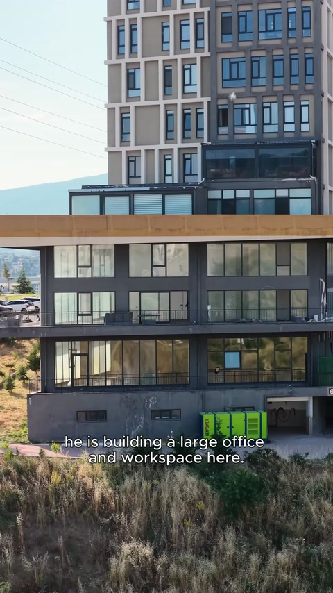 Geniş cam cepheli ofis binasının dış görünümü sergileniyor