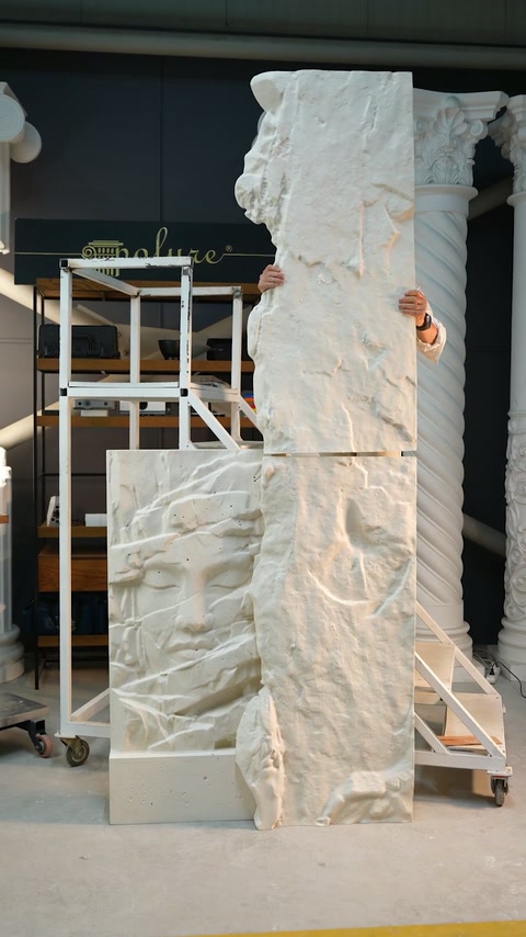 Tall textured panel sections are stacked vertically during a showroom assembly demonstration.
