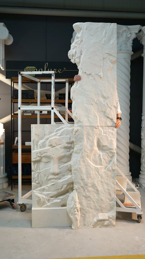 Craftsman supports the tall sculpted panel assembly near decorative display columns.