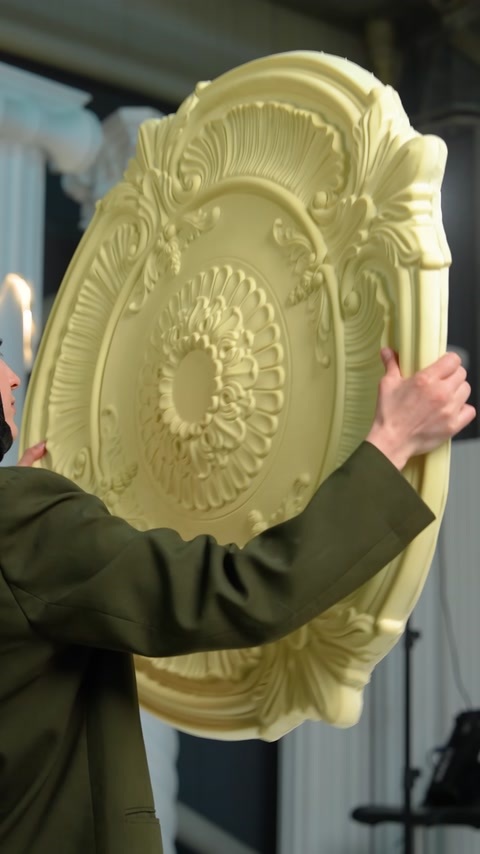 The curved edge of the ceiling medallion is stretched by hand for a close view
