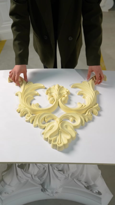 An openwork decorative ceiling motif is placed on a worktable