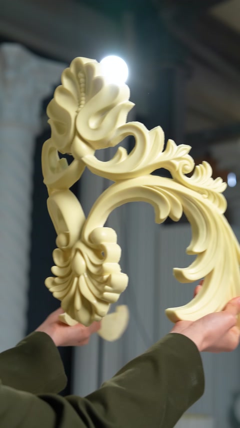 A corner ornament with botanical relief details is displayed up close