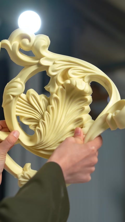 The relief details of a curved botanical motif are seen up close