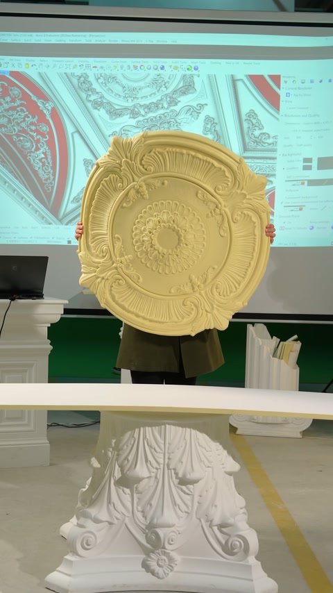 Una rosetta del soffitto circolare con motivi traforati è tenuta verticalmente dal conduttore
