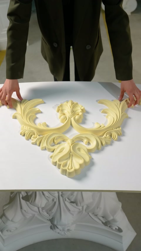 L'ornamento del soffitto a tre rami con motivi vegetali è posizionato sul tavolo bianco