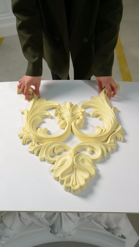 Il conduttore posiziona i rami laterali simmetrici e curvi dell'ornamento sul tavolo