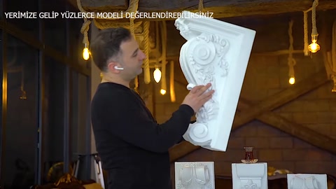 Motivo in rilievo e dettagli della cornice visibili al centro della mensola decorativa