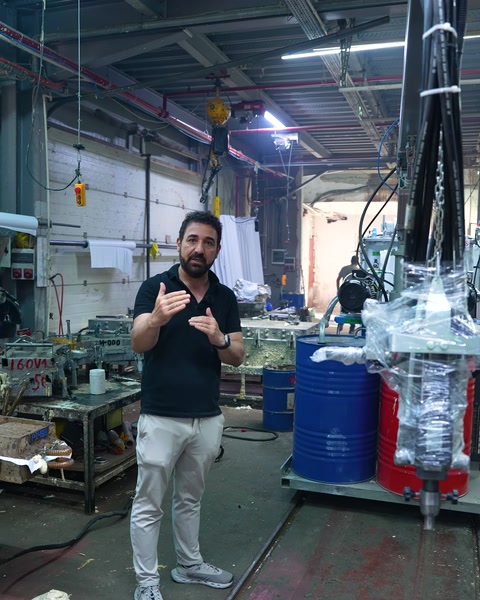 Worker presenting the polyurethane machine in front of the production line