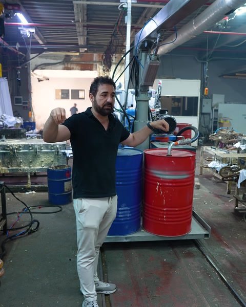 Worker describing the production process next to the mixing barrels