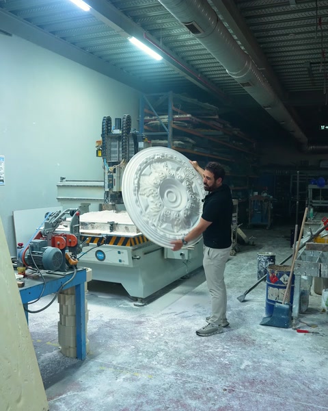 Worker carrying a newly manufactured ceiling medallion