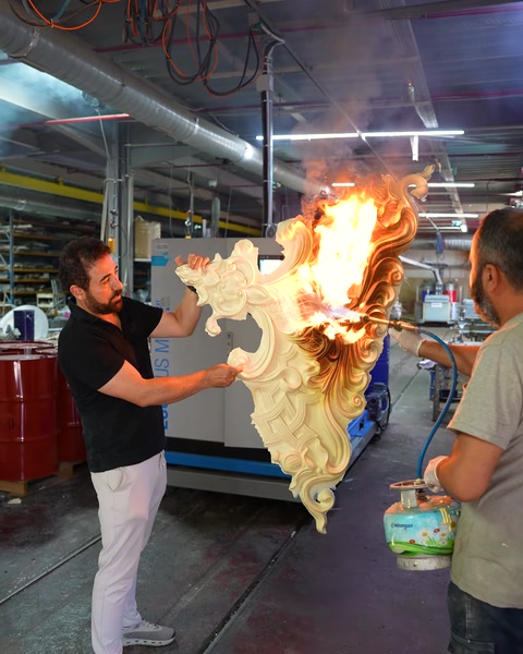 Two workers testing the burning piece with extinguishing equipment