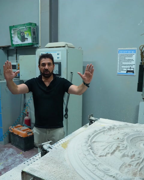 Machine operator raising his hand in front of the control panel