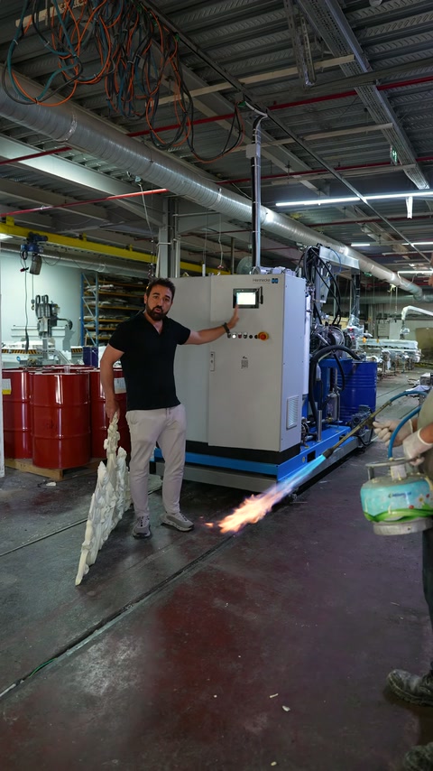 A server demonstrates a flame test on a decorative polyurethane piece on the factory floor.