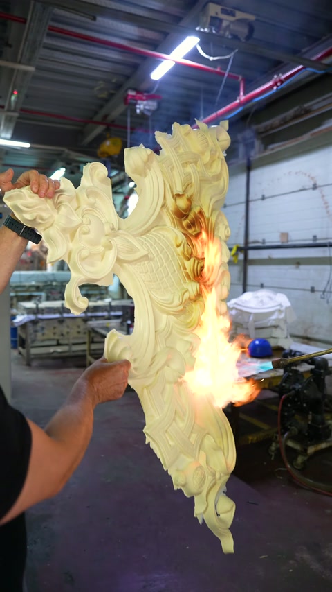 An embossed curved decorative element is closely observed with flames at its edges.