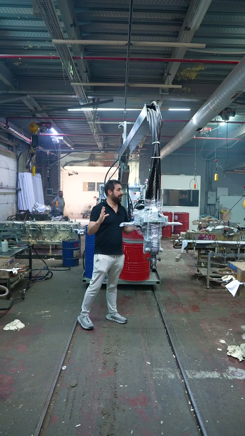 A server explains the testing process in front of machines in the production area.