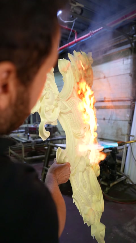 An ornamental polyurethane piece with burning edges and embossed details is shown in close-up.