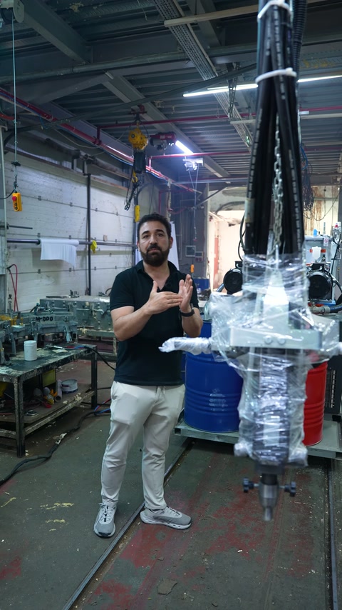 A production worker describes the experimental phase of the decorative piece in front of a machine.